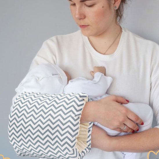Coussin d'allaitement raillé maman tient bébé dans ses bras